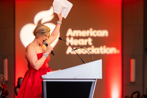 Woman in red dress at podium on stage